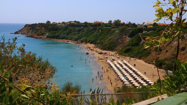 A coastal beach with umbrellas and people. - Hotel Kourkoumelata (Kefalonia)