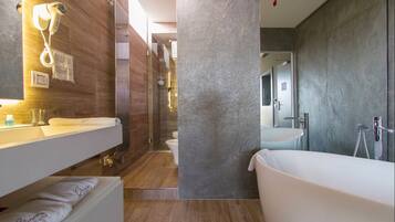 Un baño moderno con una bañera grande, un tocador con espejo y una zona de ducha.