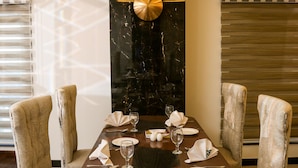 A dining area with a marble wall, a chandelier, and a patterned floor. - Hotel One Rahim Yar Khan Club Road (Rahim Yar Khan)