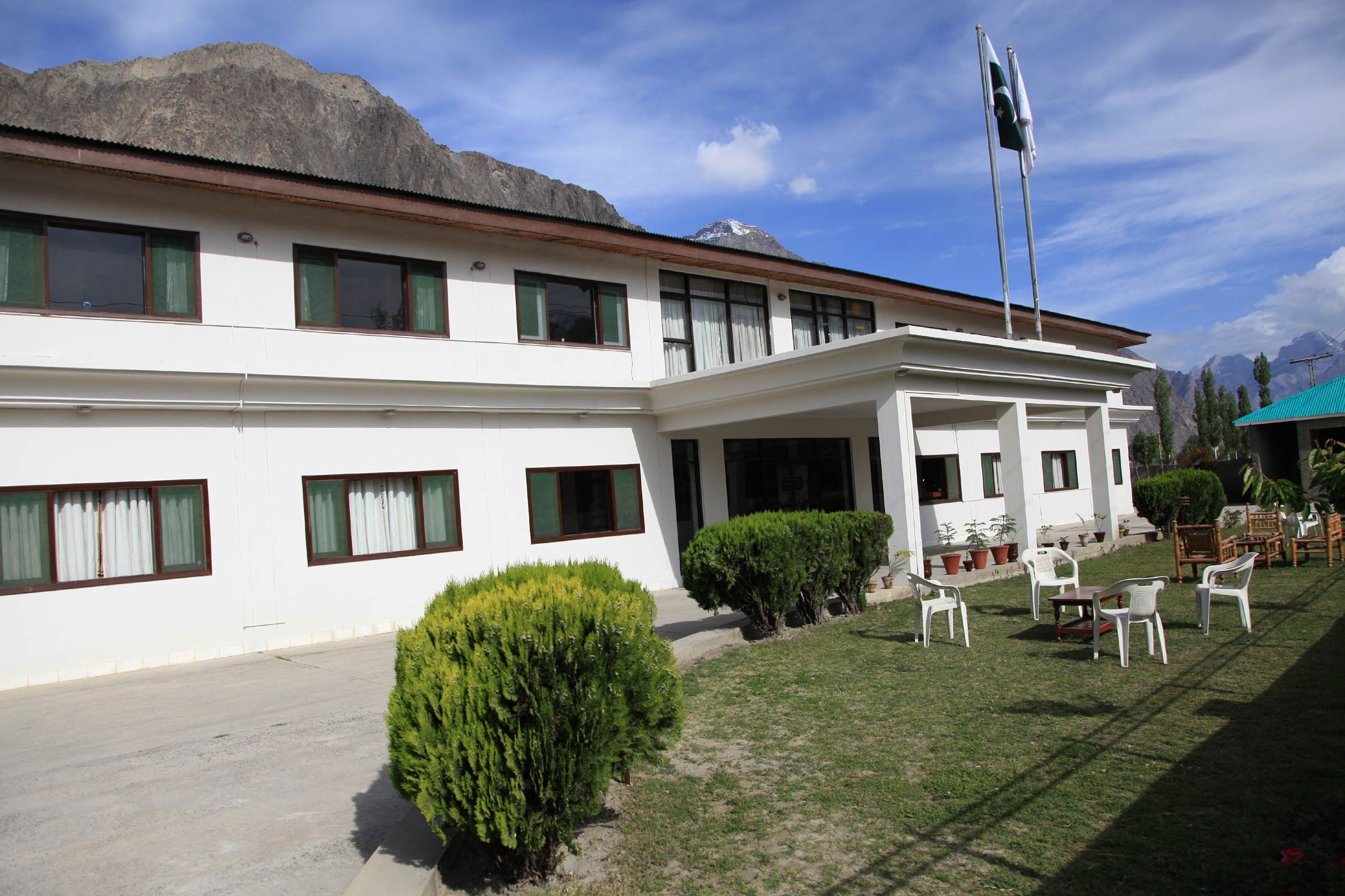 A white building with multiple windows and a flagpole.