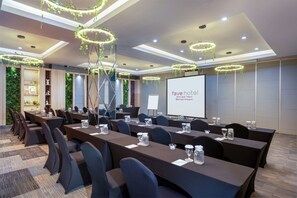 A conference room at Fave Hotel with a long table, chairs, and a projector screen. - favehotel Ahmad Yani Banjarmasin (Banjarmasin)