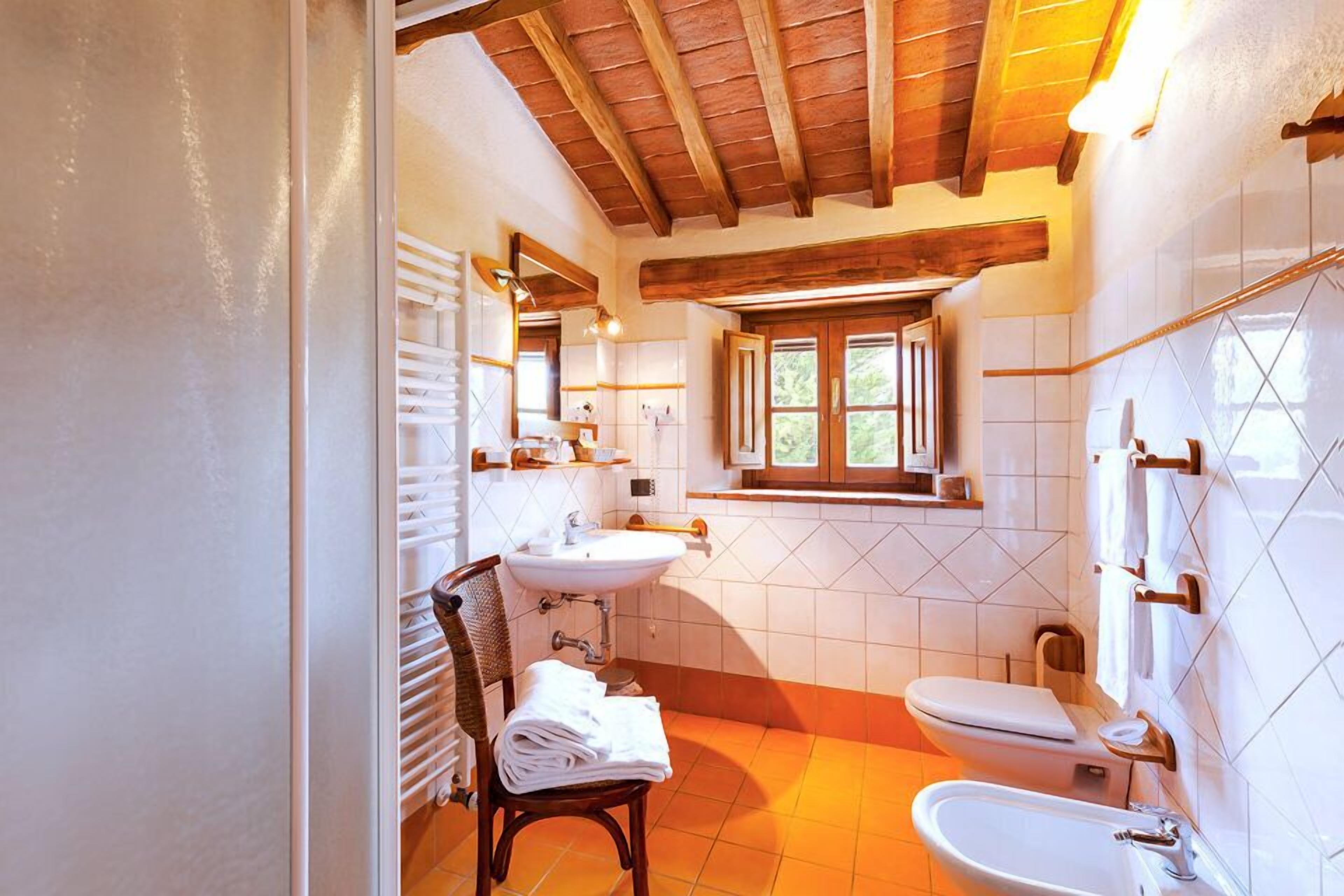 Un baño con dos lavamanos, un inodoro y una ventana.