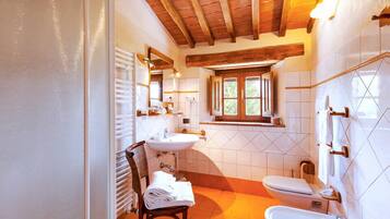 Un baño con dos lavamanos, un inodoro y una ventana.
