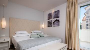 Een moderne slaapkamer met een groot bed, nachtkastjes, een bankje en kunst aan de muur.
