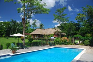 Una piscina al aire libre, tumbonas