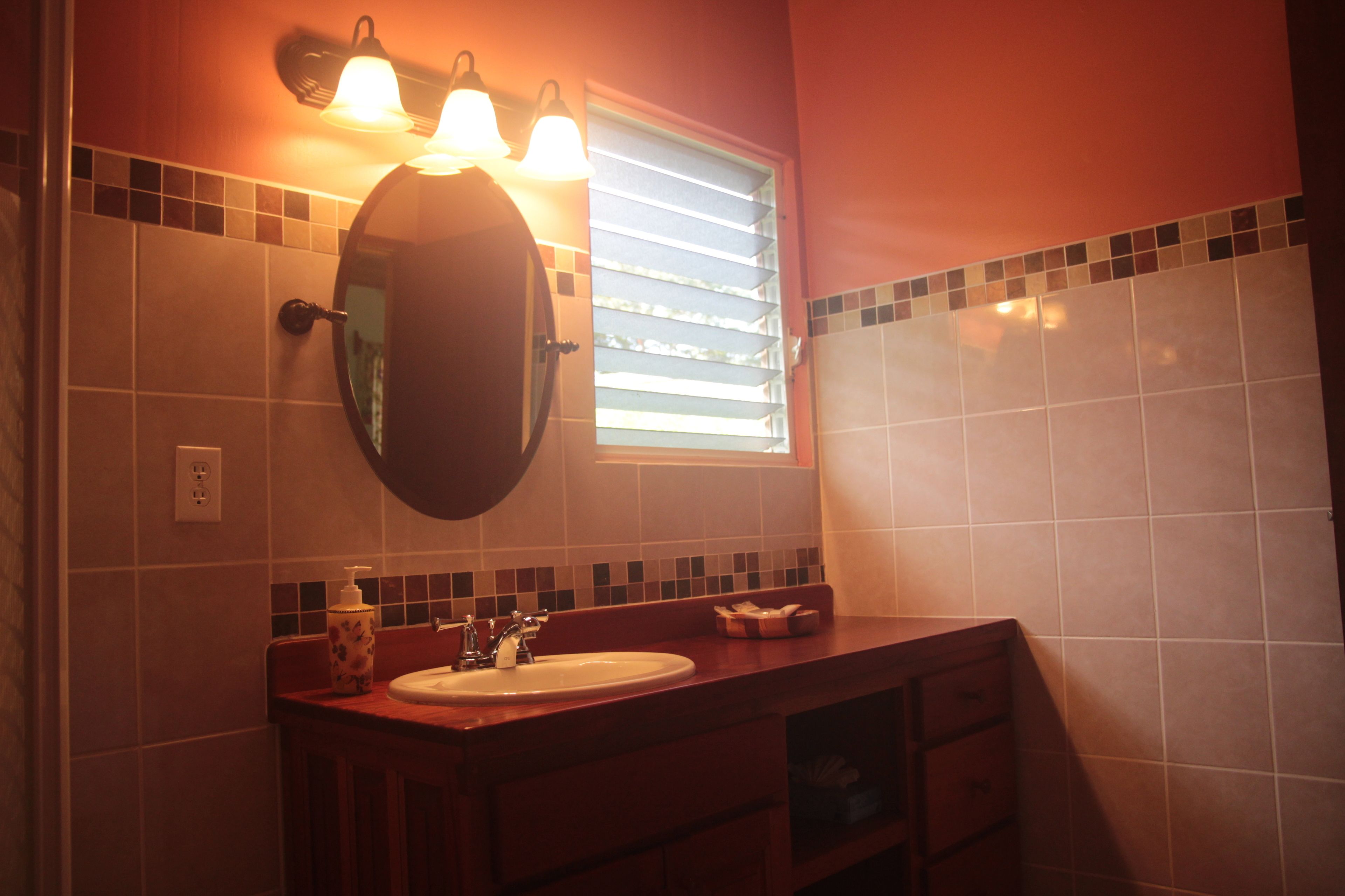 A bathroom with a sink, mirror, and two wall-mounted lights.
