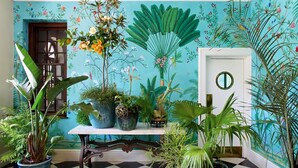 Una habitación con piso a cuadros, una puerta blanca con un espejo redondo y varias plantas en macetas.