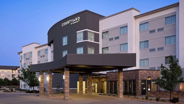 Ett Courtyard by Marriott-hotell med en inglasad entré, flera våningar och en parkeringsplats.