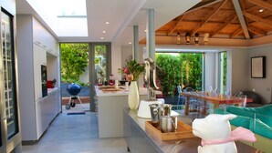 Una cocina moderna con una isla central, electrodomésticos de acero inoxidable y vistas al exterior.
