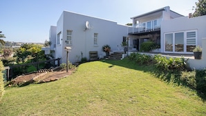 A modern two-story house with a well-maintained lawn and a satellite dish. - Dockside Guest House (Port Alfred)
