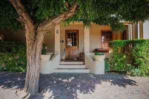 A building with a number 8 on the wall, a wooden door, and steps leading to the entrance. - Guesthouse LaRachelle (Swellendam)