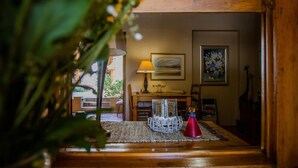A cozy room with a wooden door, a lamp, a framed picture, and a small table with decorative items. - Guesthouse LaRachelle (Swellendam)
