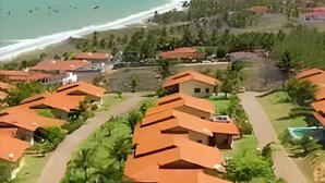Un complejo turístico con varias edificaciones, cada una con techo rojo, dispuestas en línea a lo largo de una carretera.