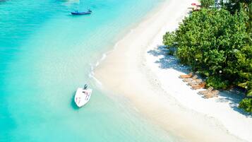 On the beach, white sand, sun-loungers, beach towels