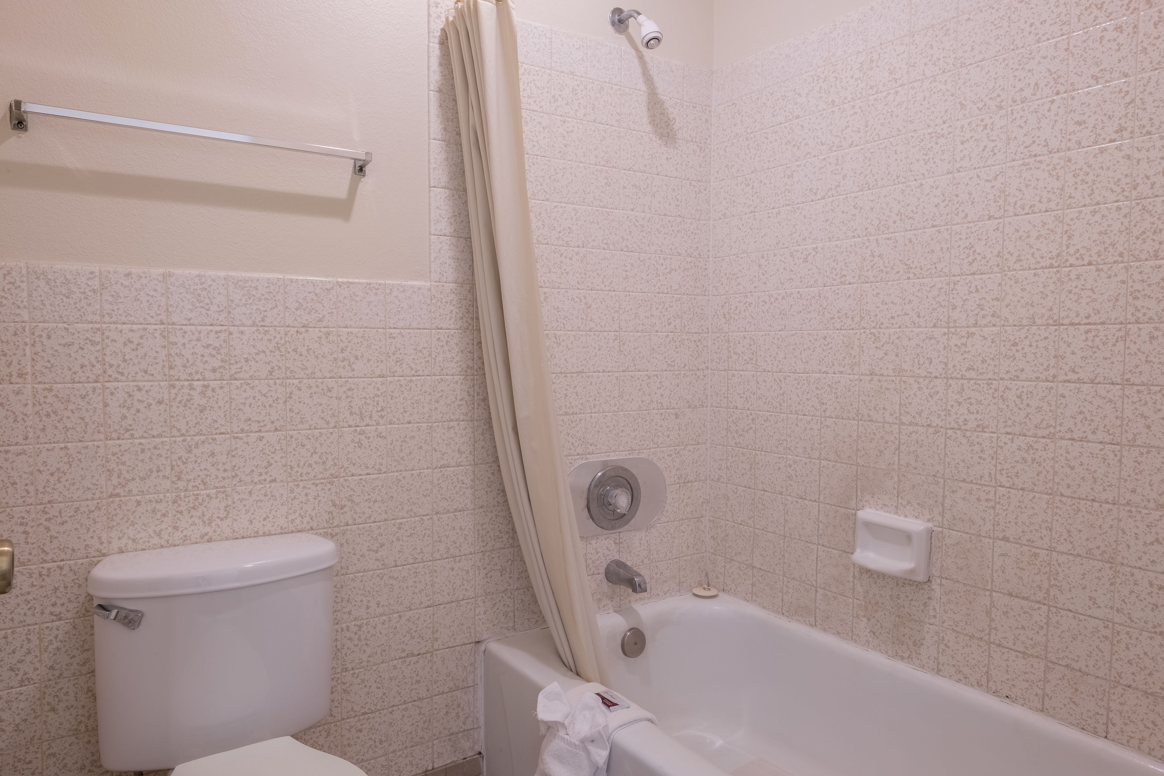 A bathroom with a toilet, bathtub, and shower curtain.