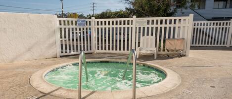 A swimming pool with a white fence and a sign that says "KEEP CLOSED."