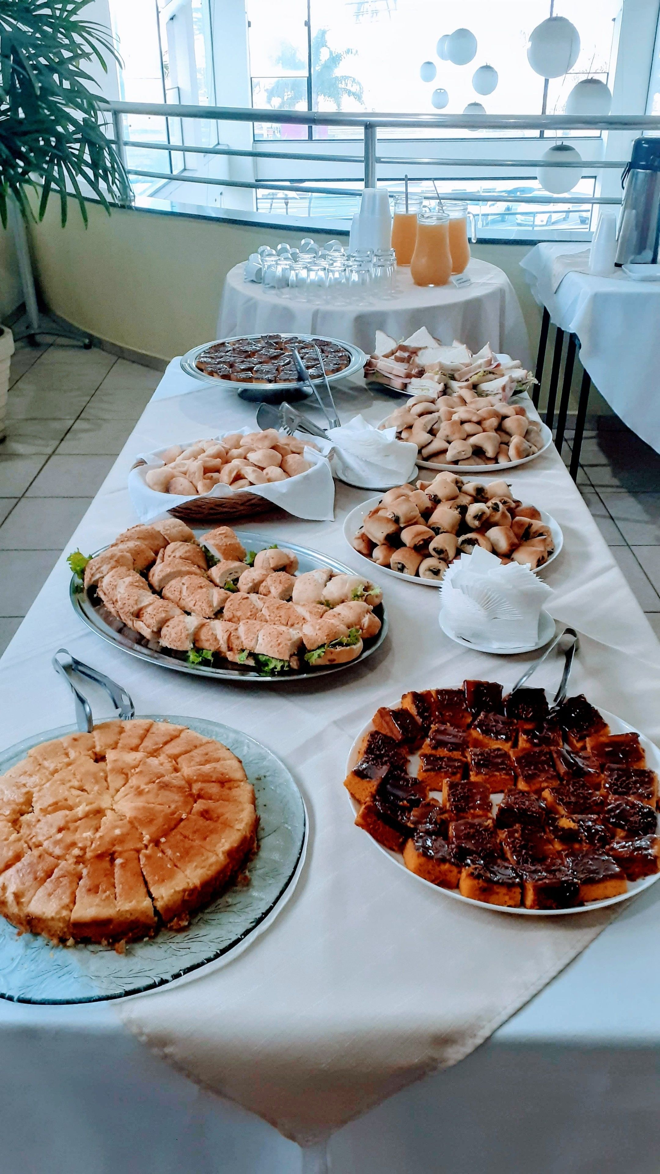 Ein Buffet mit verschiedenen Speisen, darunter Sandwiches, Gebäck und Desserts.