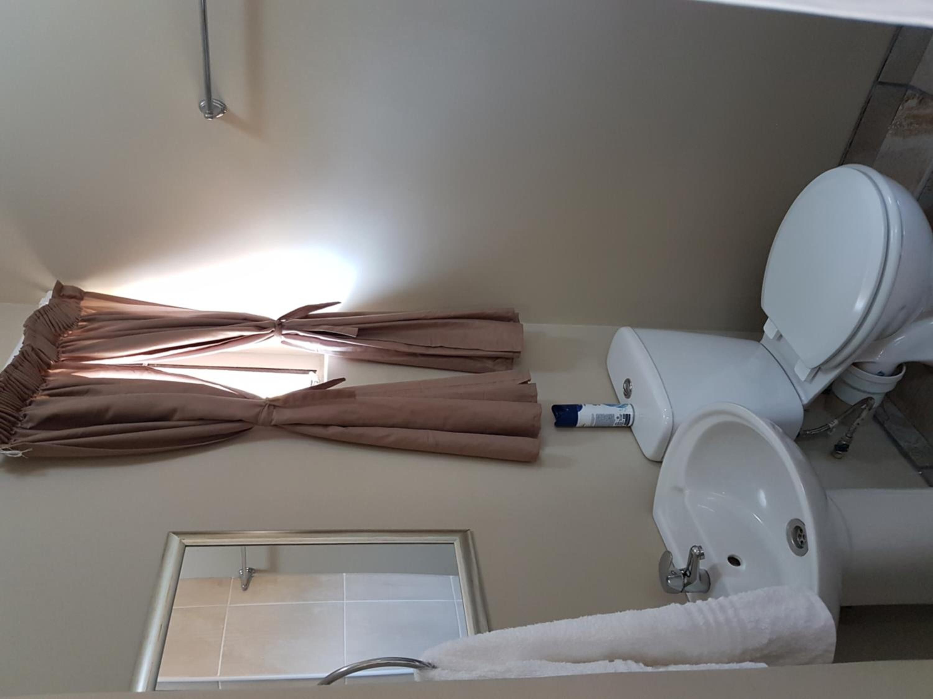 Un baño con inodoro, lavabo y zona de ducha.