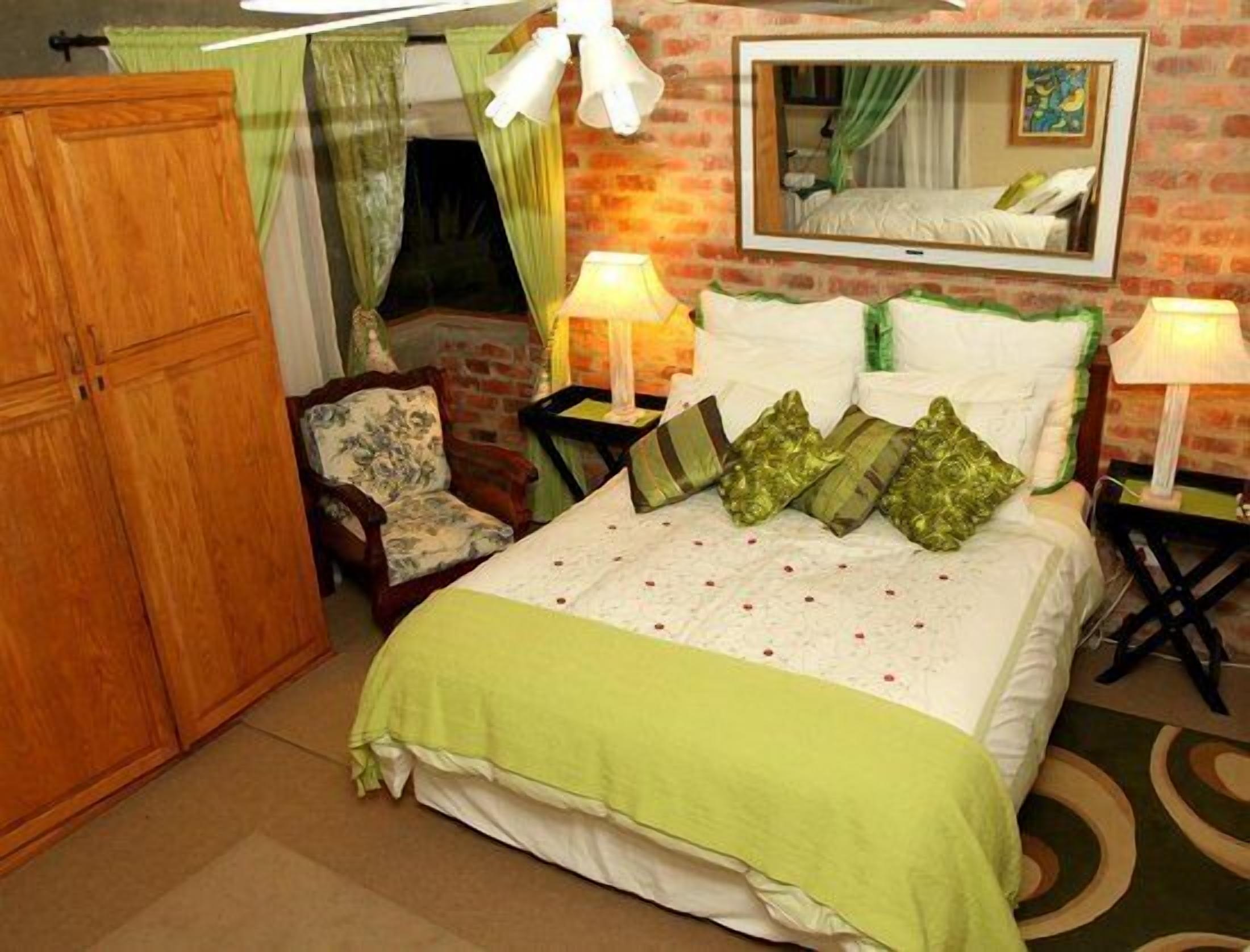 A bedroom with a bed, a chair, a wardrobe, and a mirror on the wall.