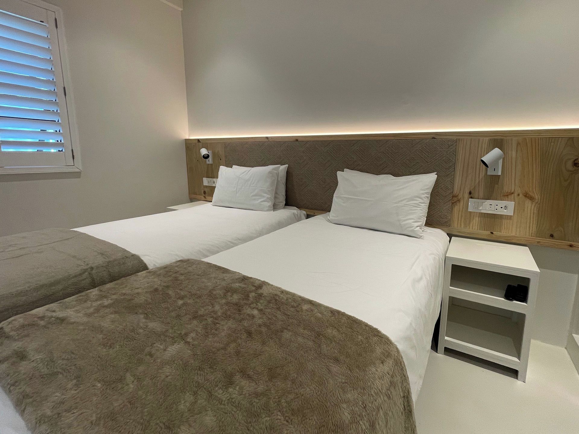 A double bed with a headboard, bedside tables, and a nightstand with a lamp.