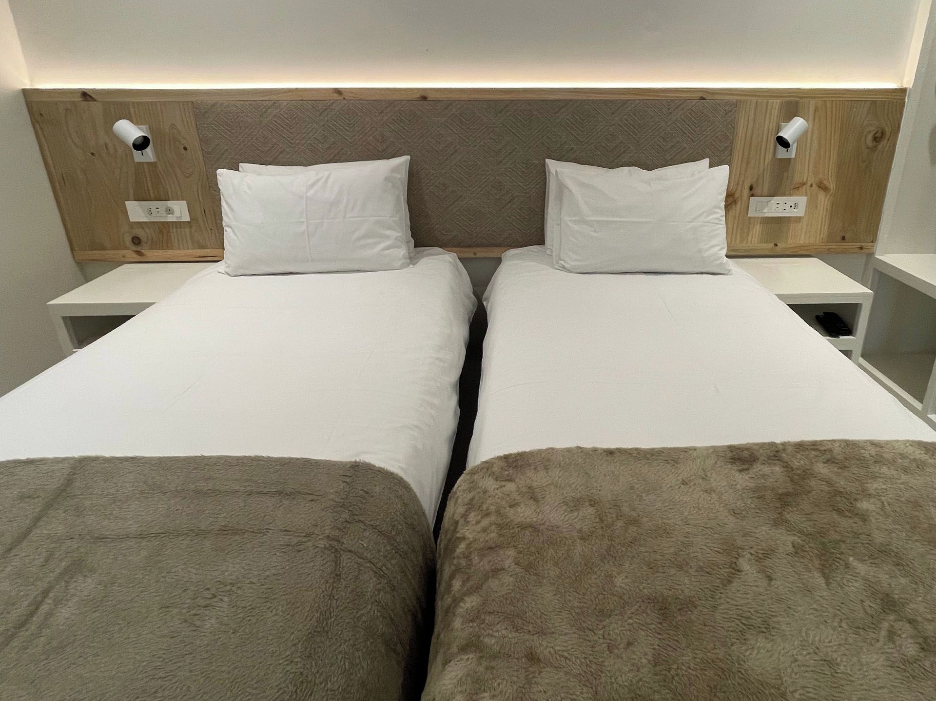A double bed with a wooden headboard and two bedside tables, each with a lamp.