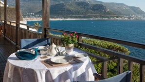 A table set for two with a view of the sea and mountains. - A Whale of a Time (Cape Town)