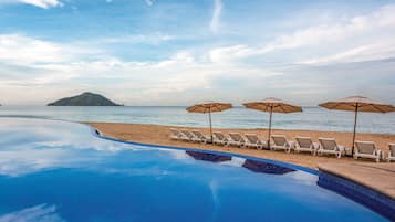 Alberca al aire libre, sombrillas en la alberca y camastros