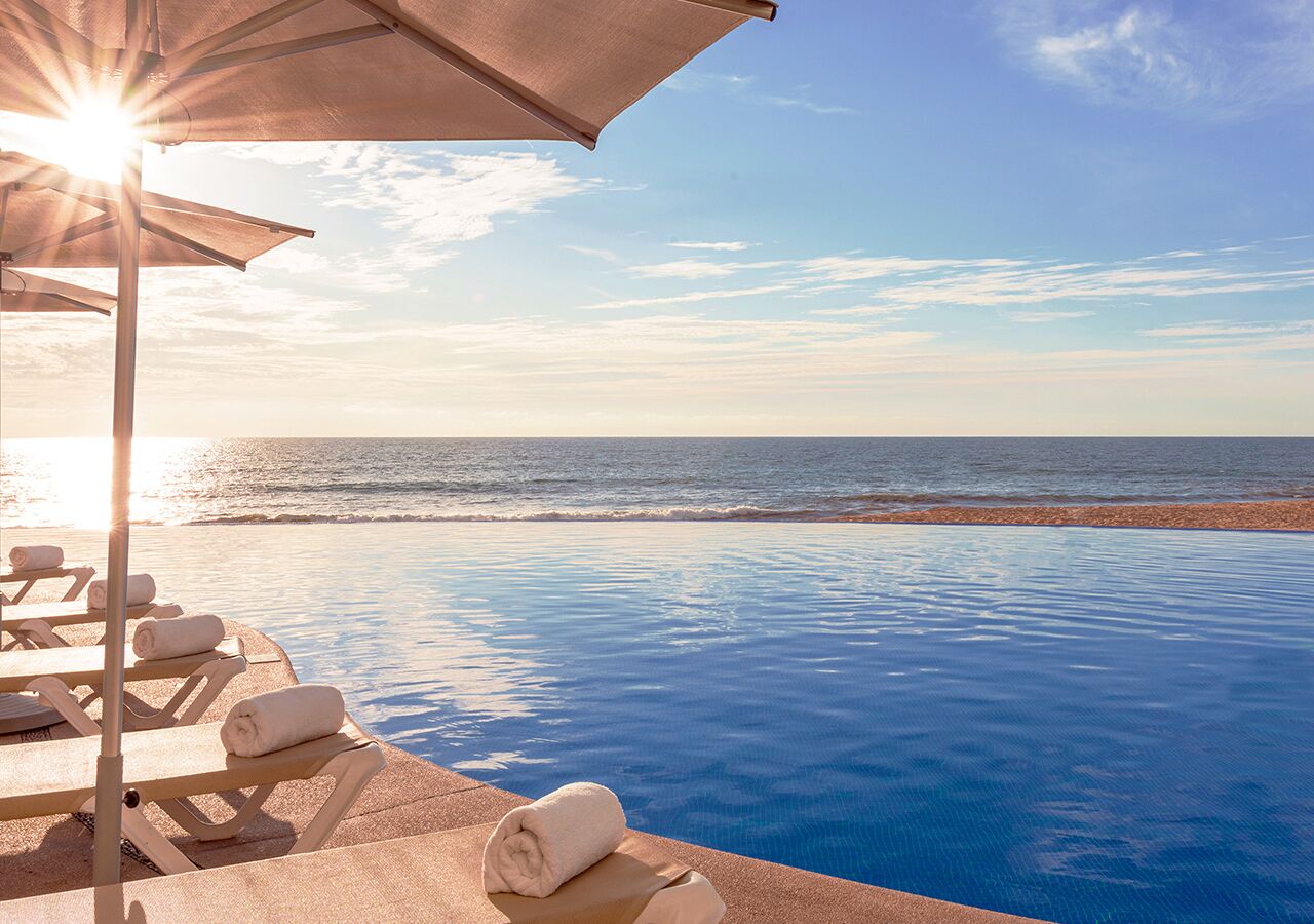 Een buitenzwembad, parasols voor strand/zwembad