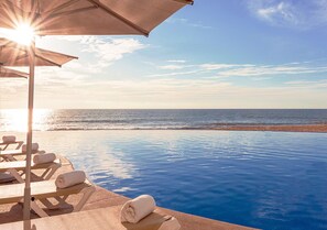 Alberca al aire libre, sombrillas en la alberca y camastros 