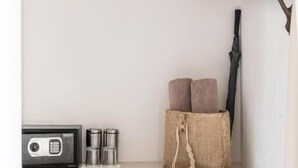 A white shelf with a radio, thermos flasks, and a burlap bag with cushions. - Tierra del Mar Hotel - Adult Only (Isla Holbox)