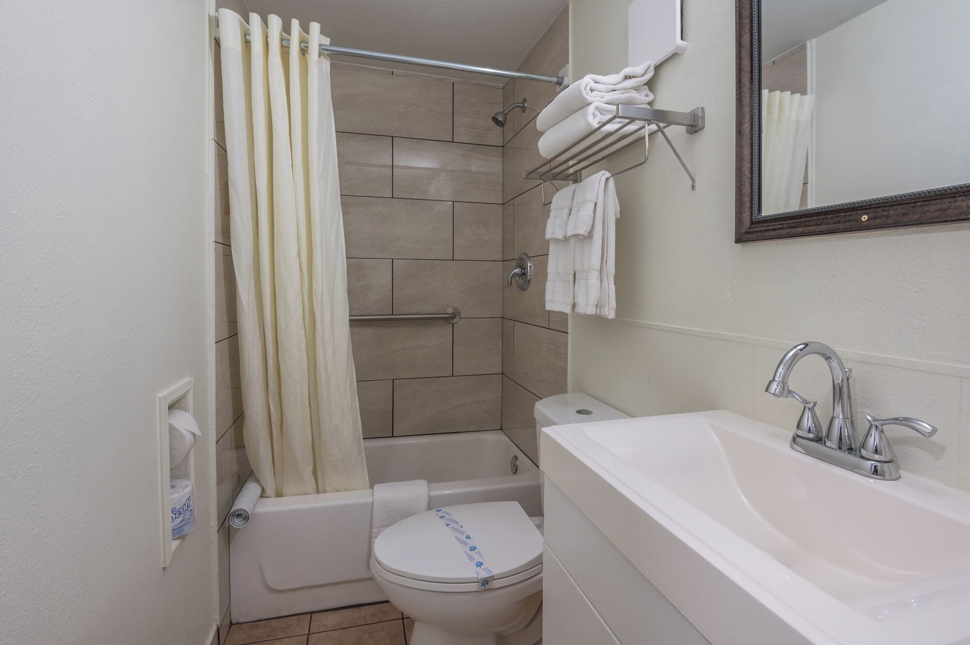 A bathroom with a bathtub, toilet, and sink.