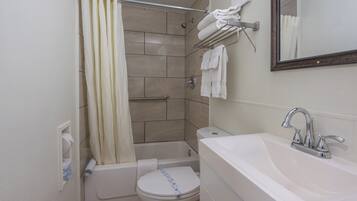 A bathroom with a bathtub, toilet, and sink.