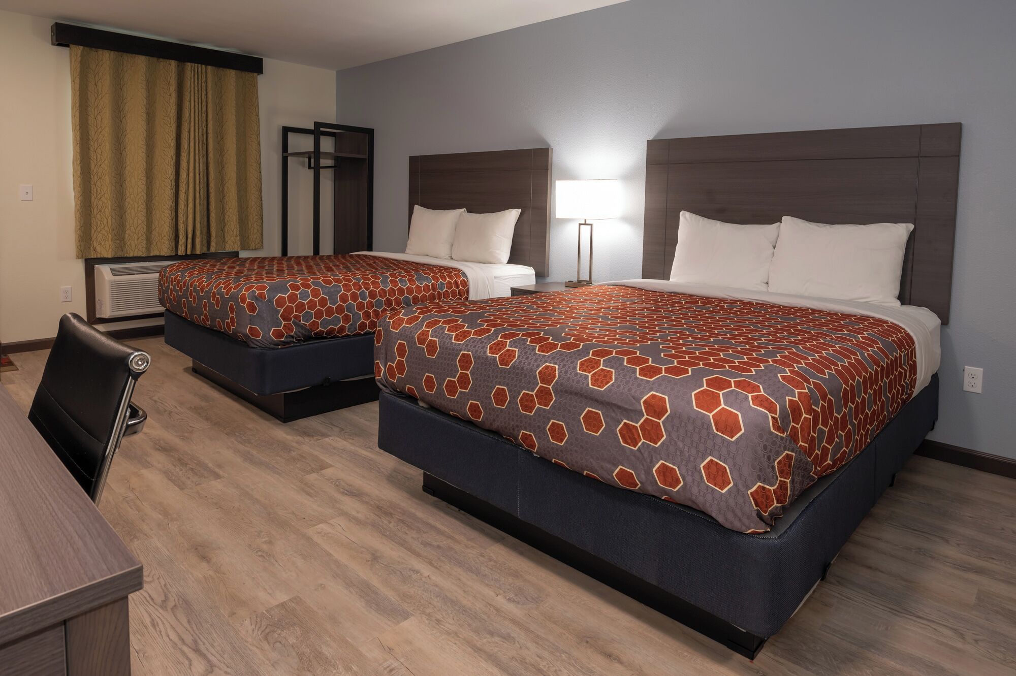 Una habitación de hotel con dos camas, un escritorio y una silla.