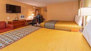 A hotel room with two beds, a desk, a chair, a TV, and a wardrobe.