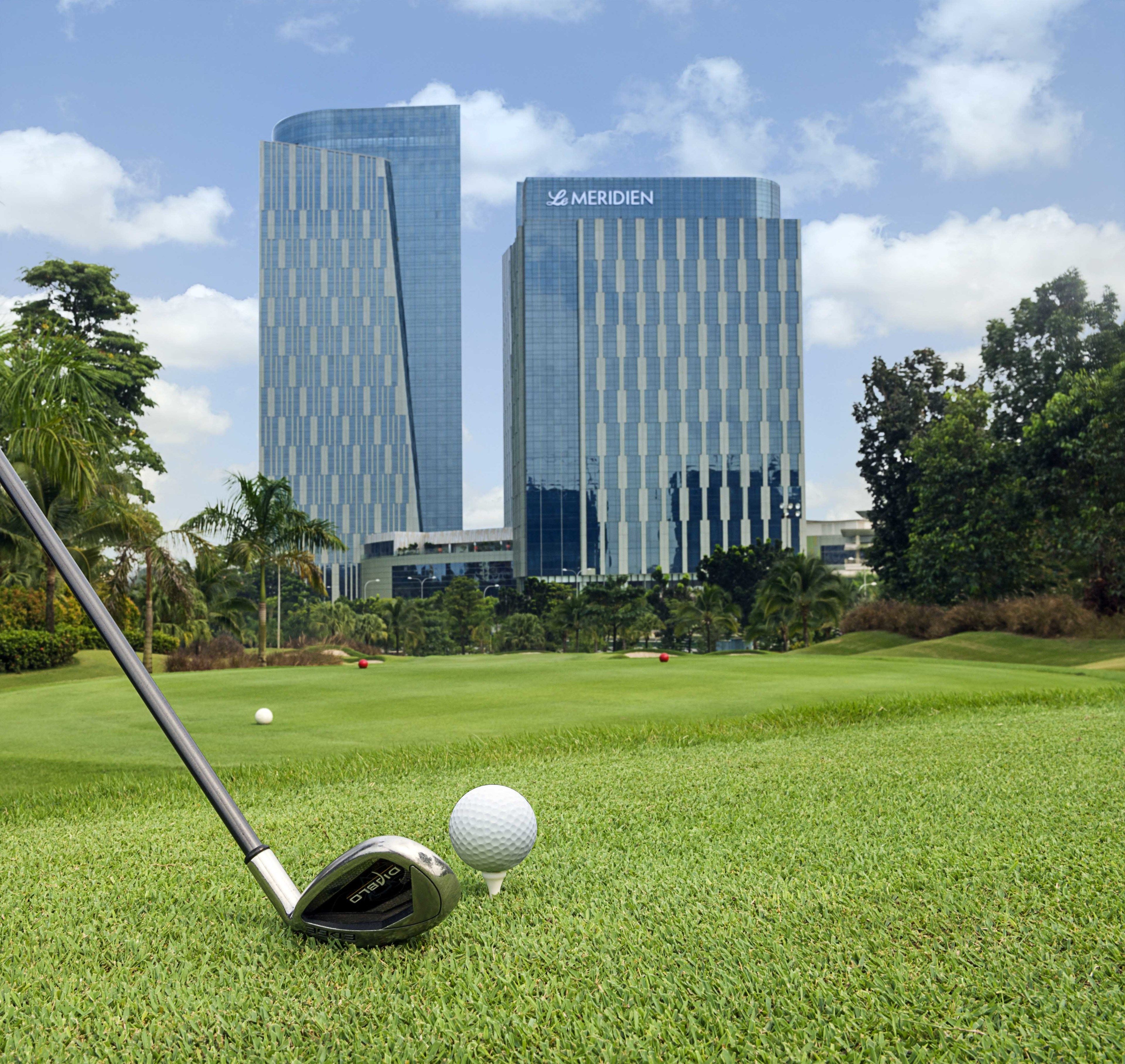 A golf course with a modern building in the background.