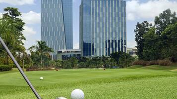 A golf course with a modern building in the background.