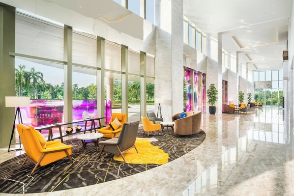 Relax in the spacious lobby with a curved seating area and large windows offering views of the surrounding greenery.
