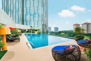 Una piscina al aire libre, sillones reclinables de piscina