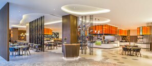 Experience the contemporary lobby with a spacious reception area, comfortable seating, and a unique light fixture.