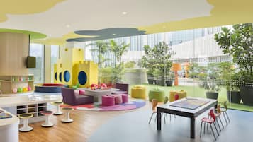 Children can play and learn in this vibrant play area with colorful seating and a castle-like structure.