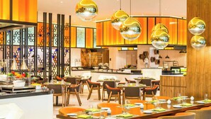 Un comedor moderno con una mesa larga, múltiples sillas e iluminación colgante.