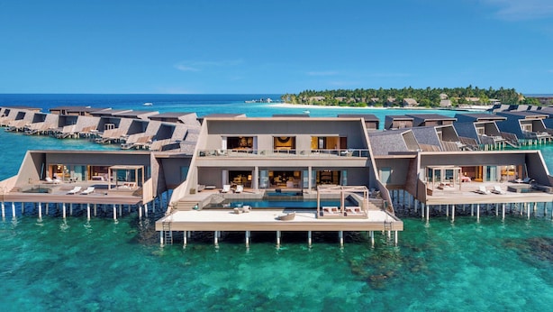 A luxurious overwater villa with multiple balconies, clear blue waters, and a view of the ocean and distant island. - The St. Regis Maldives Vommuli Resort (Vommuli)
