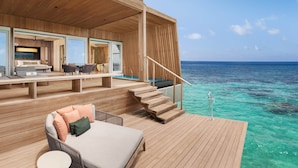 A wooden deck with a sofa and chairs, a staircase leading to an upper level, and a view of the ocean. - The St. Regis Maldives Vommuli Resort (Vommuli)