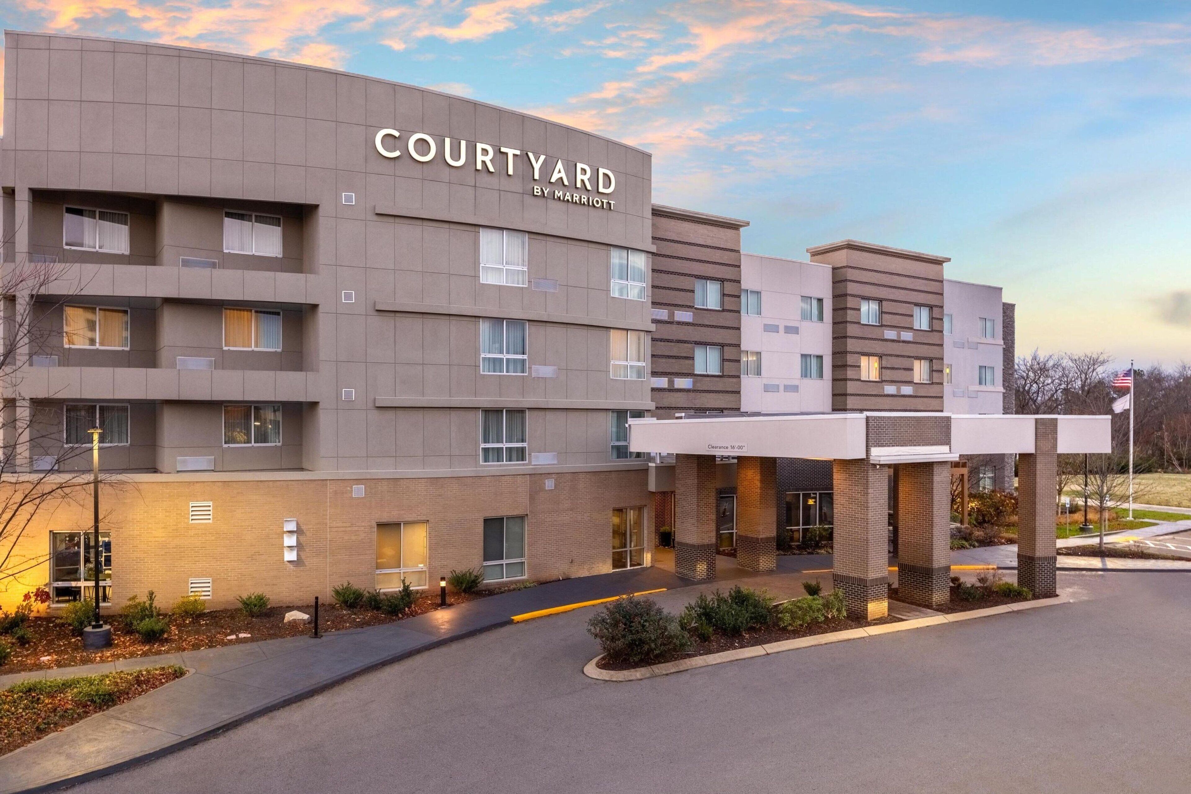 A Courtyard by Marriott hotel with a modern design, multiple floors, and a covered entrance area.