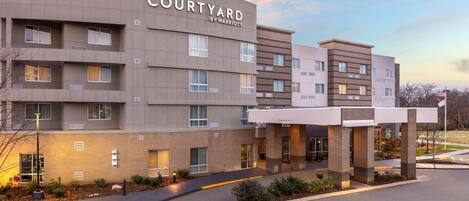 A Courtyard by Marriott hotel with a modern design, multiple floors, and a covered entrance area.