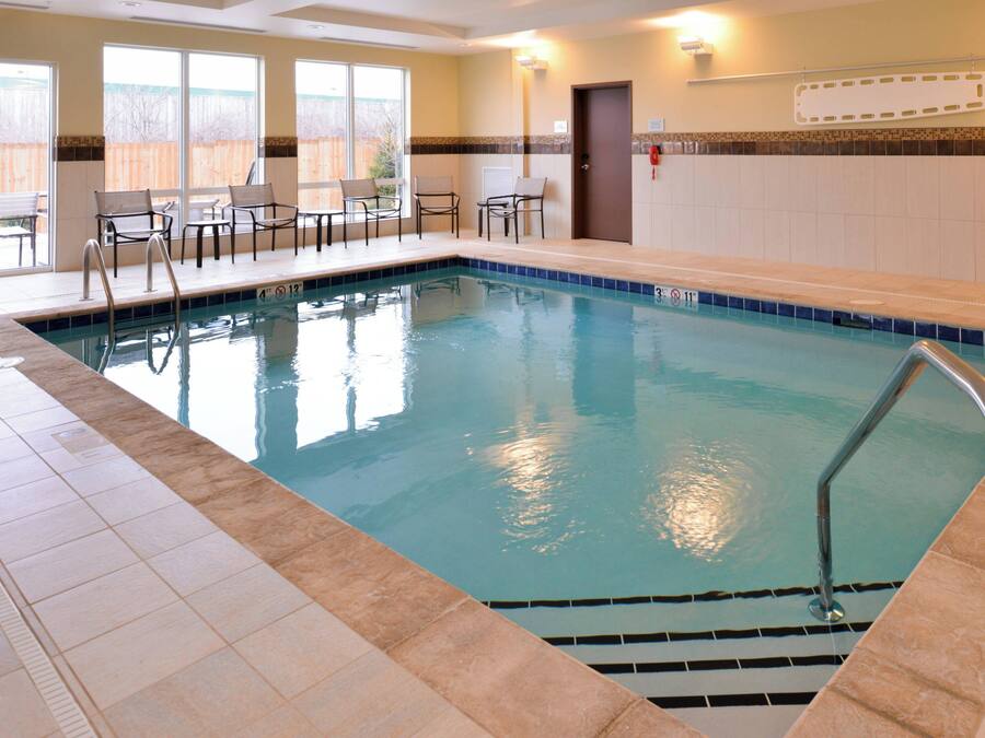 An indoor swimming pool with clear water, tiled edges, and a lifeguard ladder.
