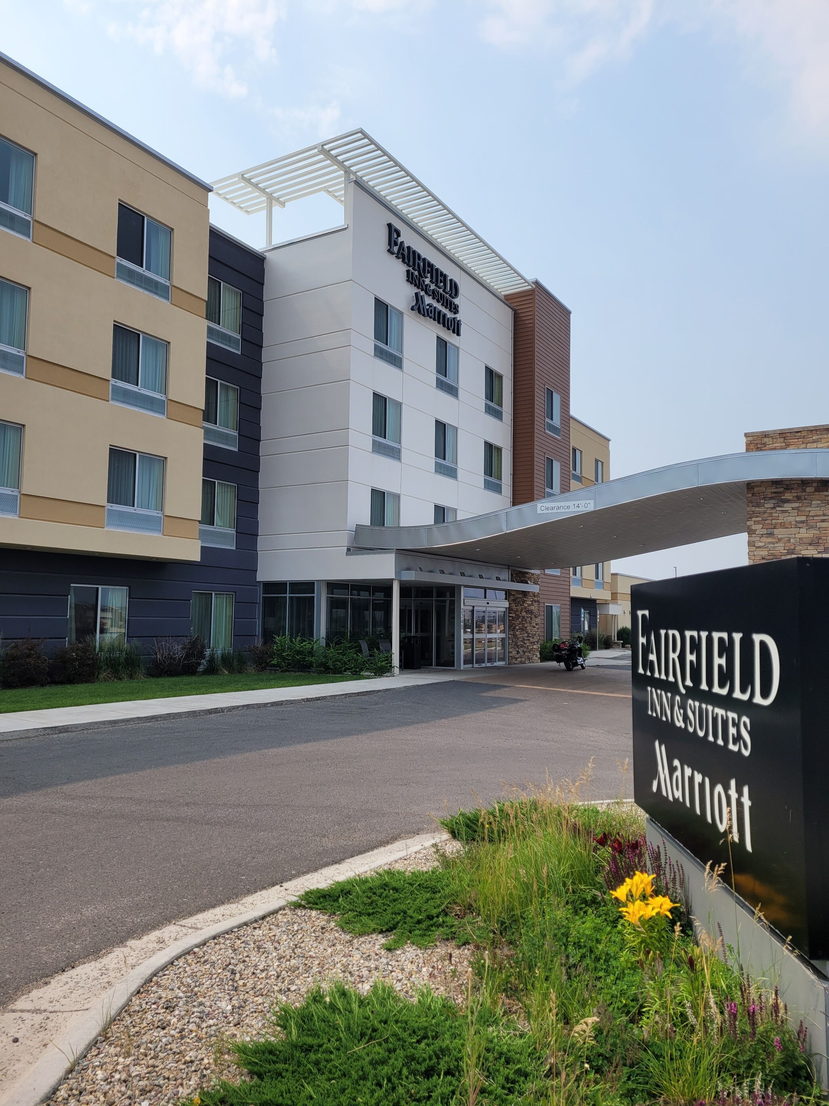 A Fairfield Inn & Suites Marriott hotel with a modern design, featuring a large entrance and a covered walkway.
