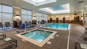 An indoor swimming pool with clear lanes, lounge chairs, and a skylight ceiling. - Fairfield Inn & Suites by Marriott Butte (Butte)