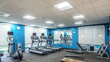A gym with treadmills, elliptical machines, and weight benches.