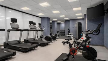 A gym with treadmills, ellipticals, and a stationary bike.
